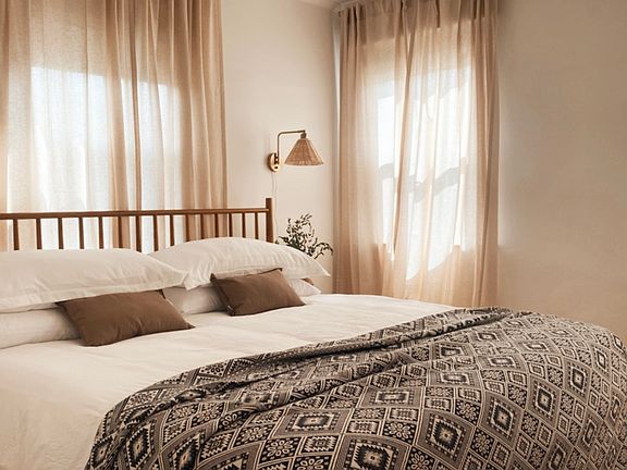 Primary bedroom with curtains for privacy and room darkening shades for sleeping.