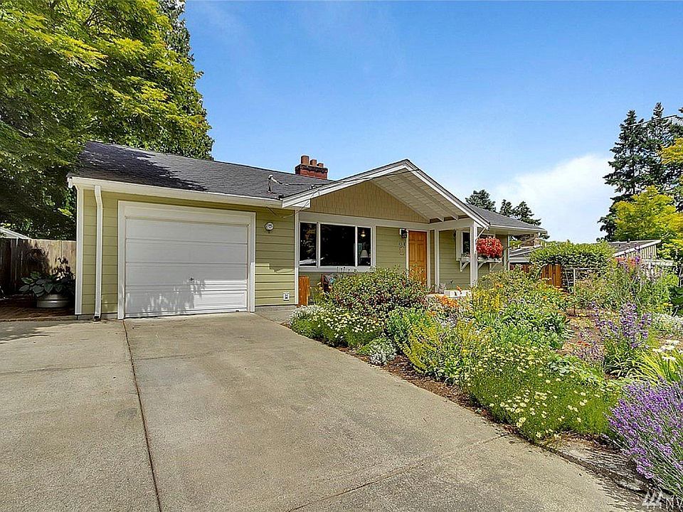 Front of house with attached garage and off-street parking.