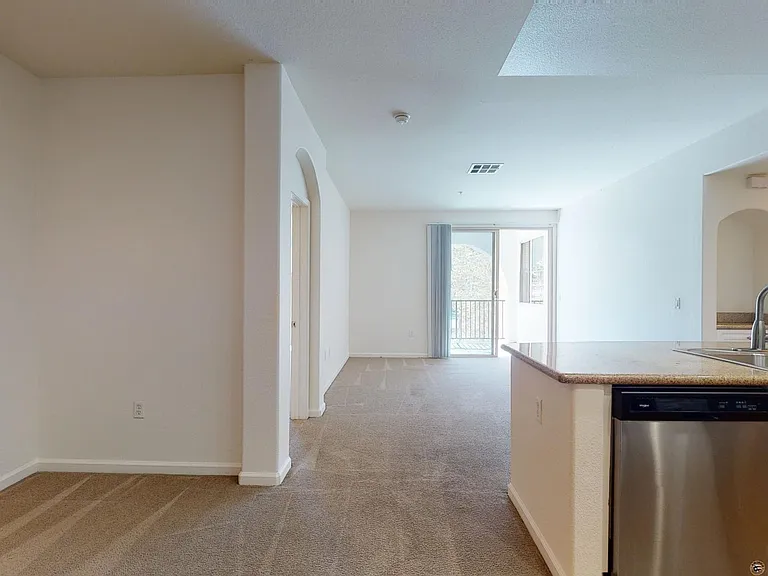 Apartment living room with plush carpet flooring.