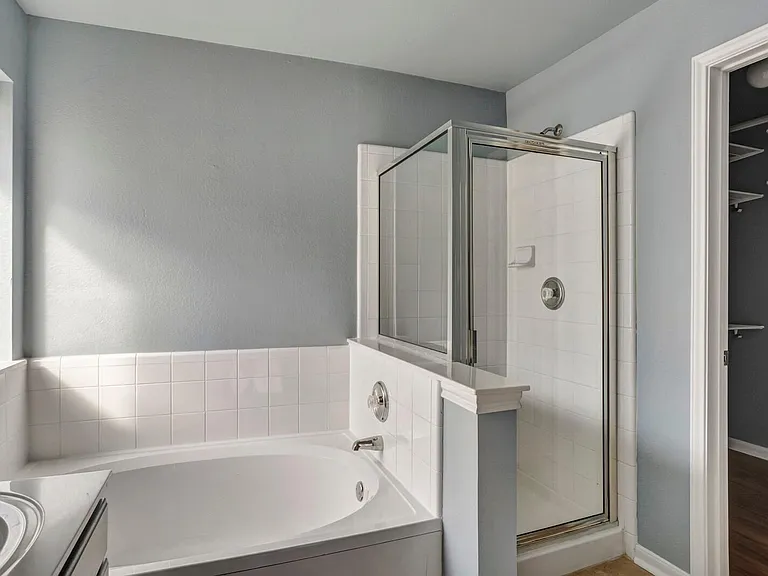 Master bathroom with large bath tub and stand up shower.