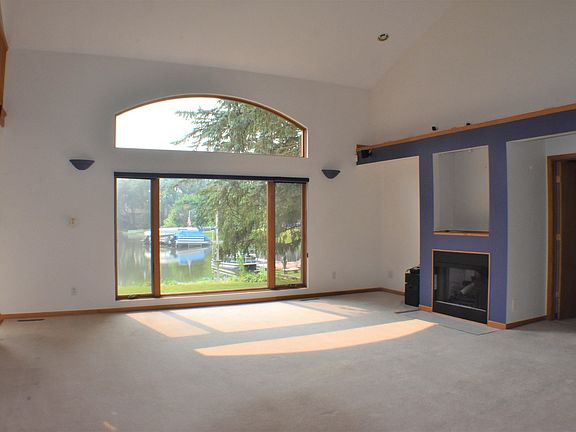 Living room has a nice fireplace and entertainment center with surrounds sound speakers.