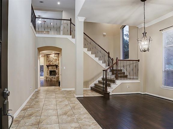 Grand entrance with stairwell, formal dining, and fireplace.