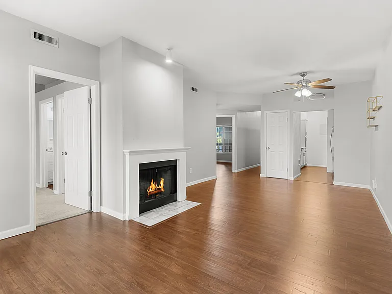 Spacious living room with tall ceilings, a wood-burning fireplace, and durable LVP flooring throughout.