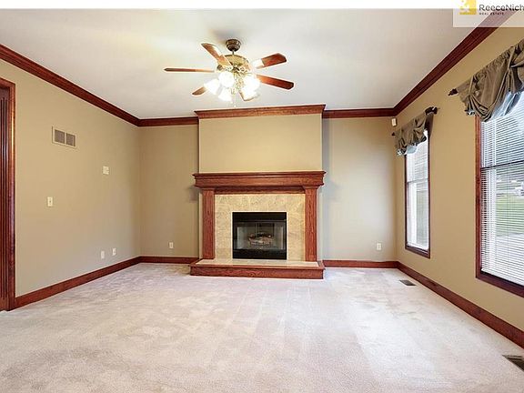 Living Room with crown molding and large windows