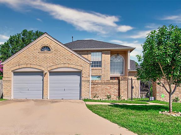Street view of home showing double wide driveway and pear tree in front yard.