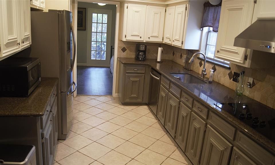 Beautiful updated kitchen with the view to the formal dining room. Window view to yard and pool.