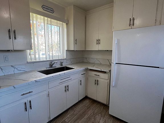 Kitchen with quartz counter tops includes fridge, stove and ceiling fan.