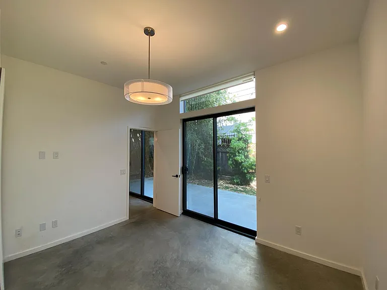 Primary bedroom has sliding door leading to private backyard.