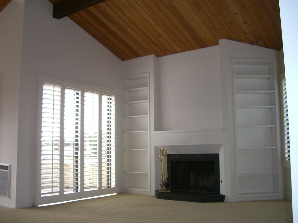 Living room with fireplace, vaulted ceiling & private deck