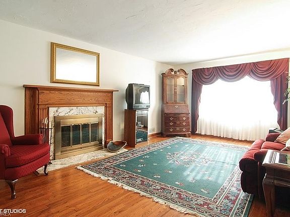 Spacious living room with a warm neutral marble fireplace and grand window to let the sun shine in!