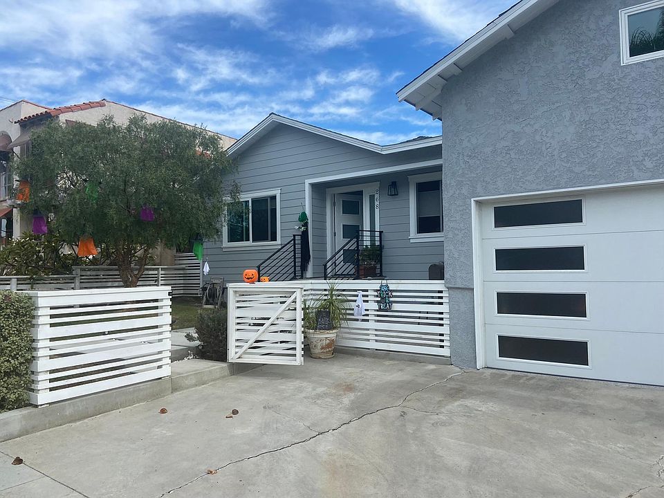 Front steps, front yard, patio, garage, and parking area.