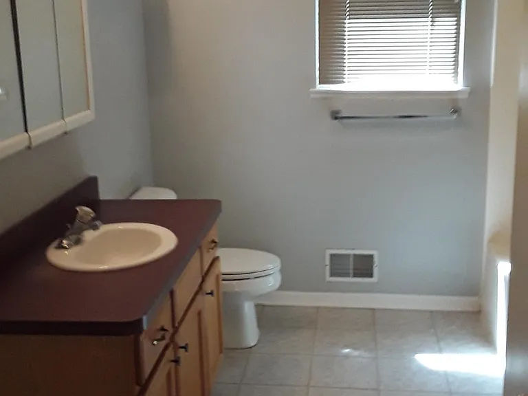 Bathroom with four foot long vanity and full bathtub and shower.