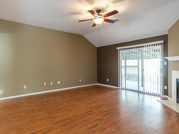 The large den has laminate wood floors and high ceilings. The sliding doors lead out to a covered patio and nice size yard.