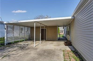 Carport with privacy screen and large storage area.