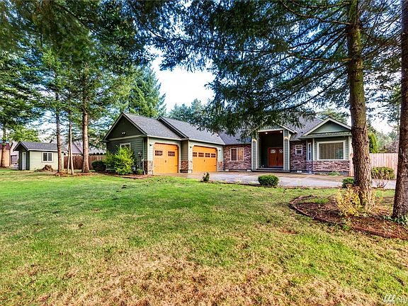 Surrounded by beautiful evergreen trees, the front of the property is spacious and low maintenance.