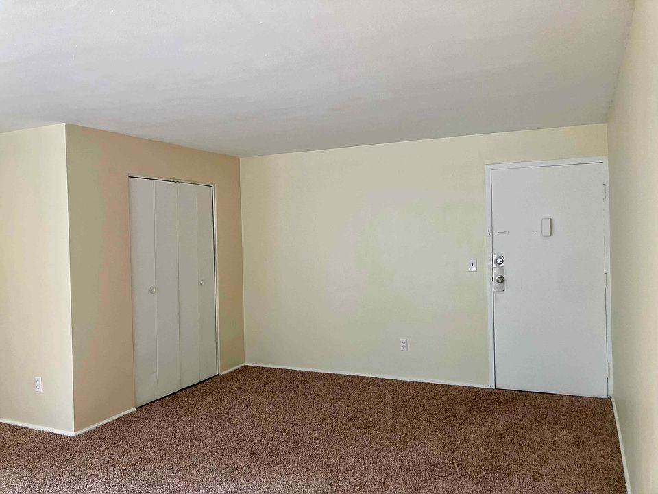 Living room area looking towards closet and entry door