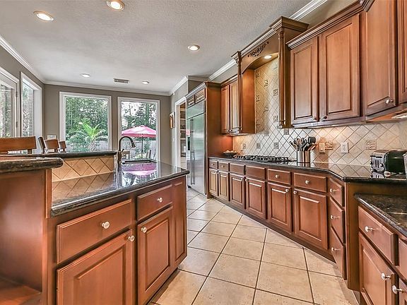 Another view of the beautifully designed kitchen with plenty of countertop space and storage.