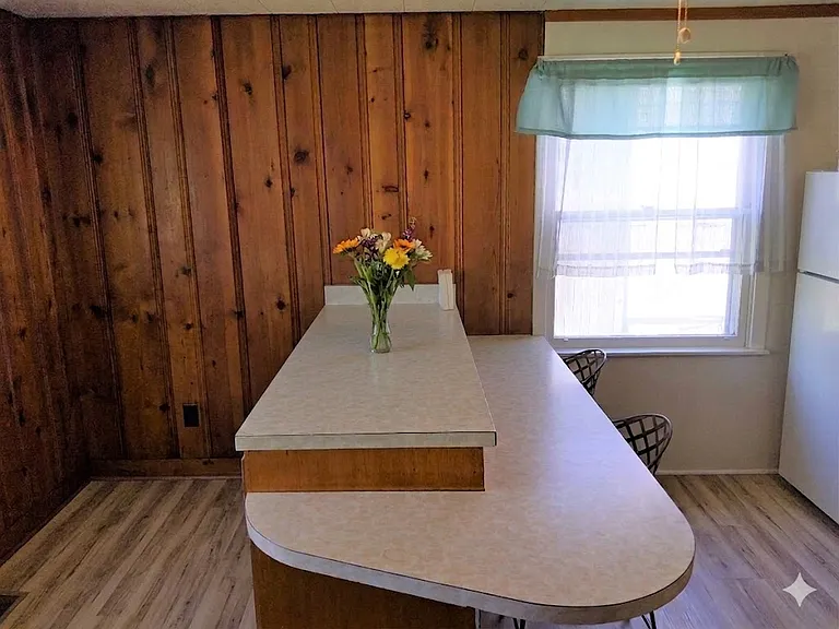 Island breakfast bar with stools! Wonderful knotty pine accent walls.