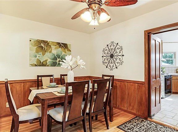 Dining Room with Wainscoting and Swing Door to Kit