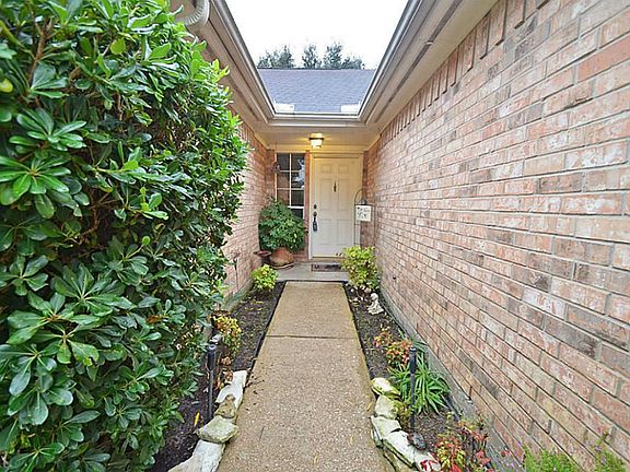 Entryway, notice the brick on the home and full gutters with mature landscaping.