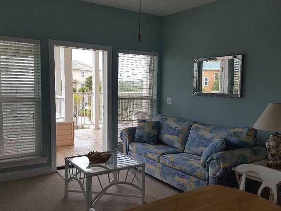 Living area off kitchen with sleeper sofa and porch access.
