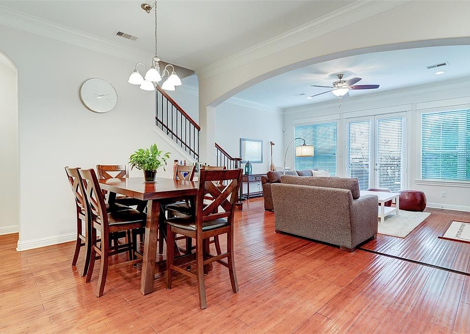 View of the open floorpan dining room and living room, featuring hardwood floors throughout.