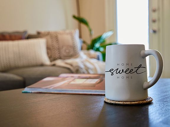 Mug with Home Sweet Home text on it on a table in a living room
