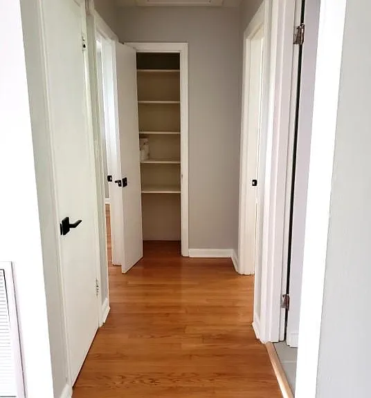 Bedroom hallway view, with linen closet. Doors feature square rosettes.