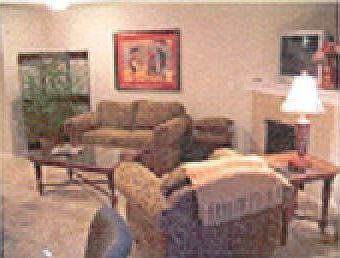 Open living space with fireplace, patio, and small fenced yard