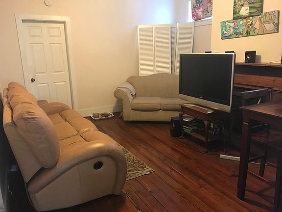 large den/common area with beautiful hardwood floors and mantle.