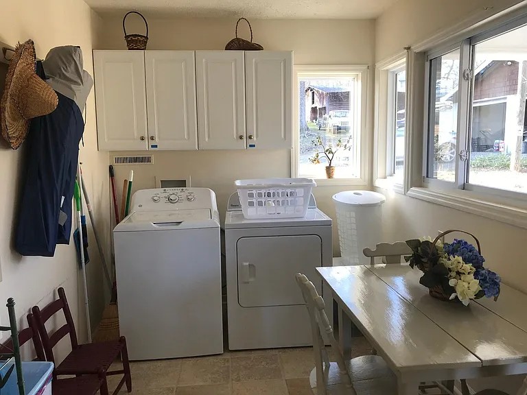 Ample sized laundry room with washer and dryer and cabinets for storage.