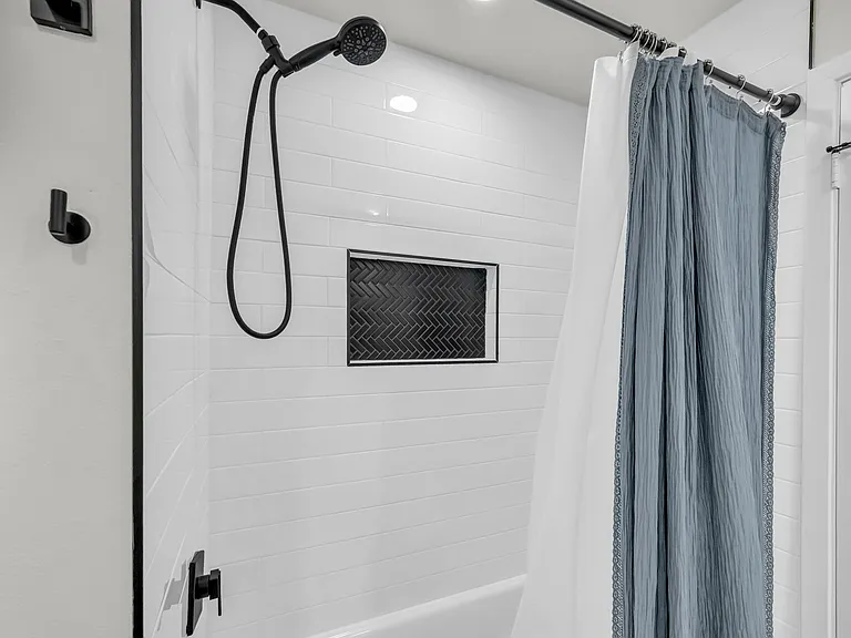 Hallway bathroom with tub and shower