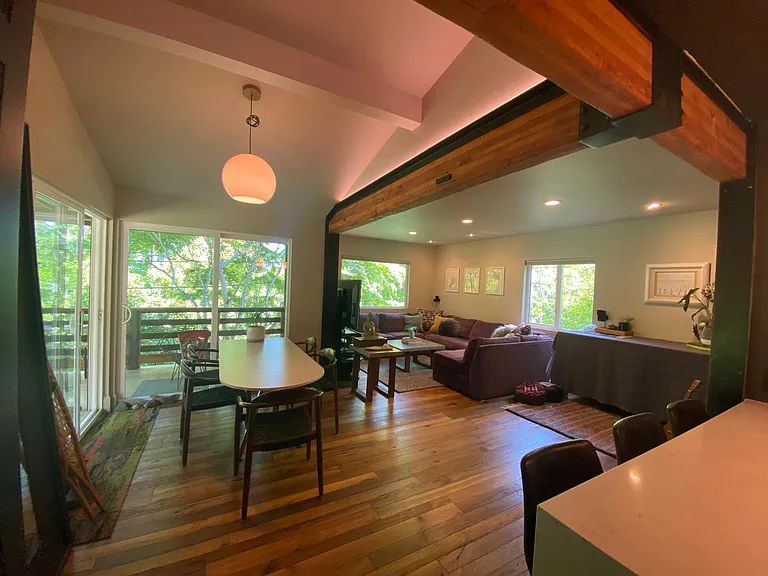 Home perched on hillside offering views through tree canopy throughout.