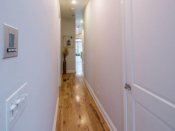 Hallway from living room towards kitchen which accesses othe