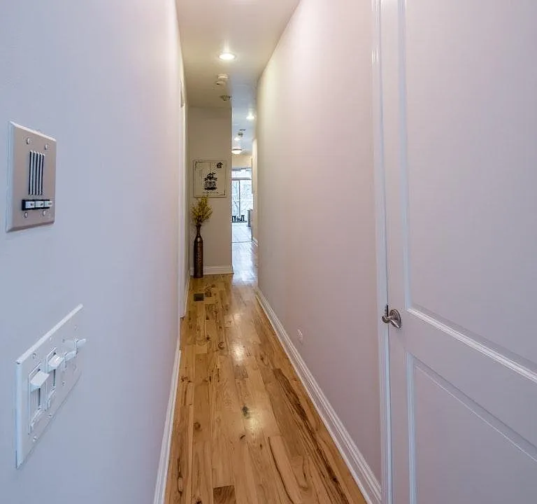 Hallway from living room towards kitchen which accesses othe