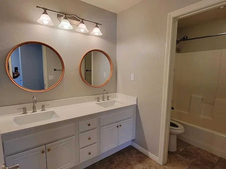 shared hallway bathroom, dual sink , toilet and shower
