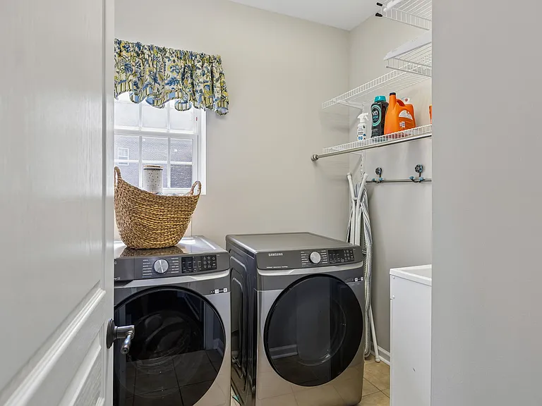 A spacious laundry room with utility sink, storage shelving & natural light adds convenience and functionality for tenants. The washer & dryer are here for your use!
