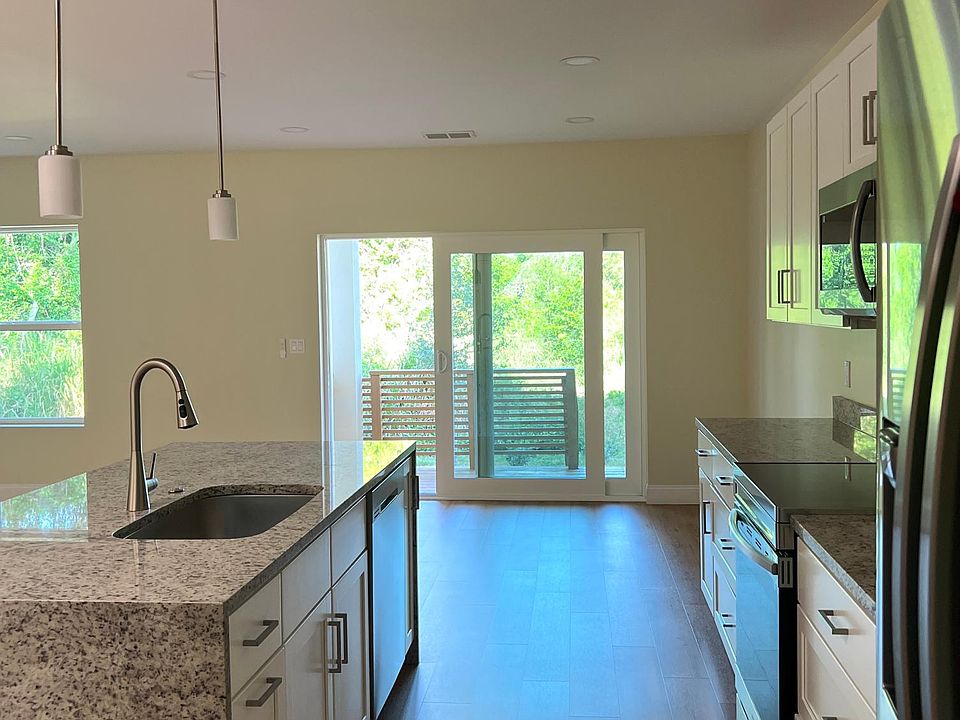 Kitchen area with beautiful wooden balcony and trees in the backyard