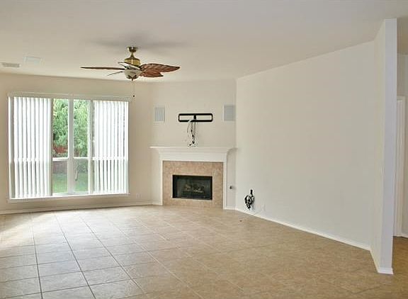 Large living room overlooks lush backyard, and is replete with surround sound and custom wiring, and has a gas log fireplace!
