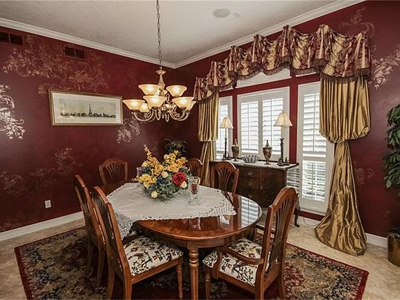 Custom paint and silk drapes add to the elegance of the formal dining room.