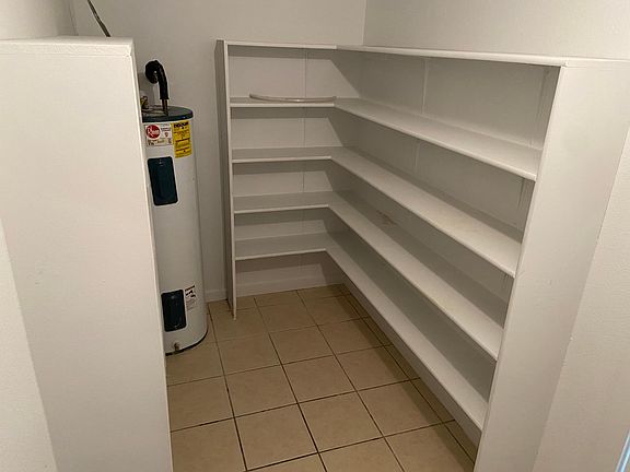 Over-sized walk-in pantry with custom shelving and porcelain tile floors make staying organized a breeze!