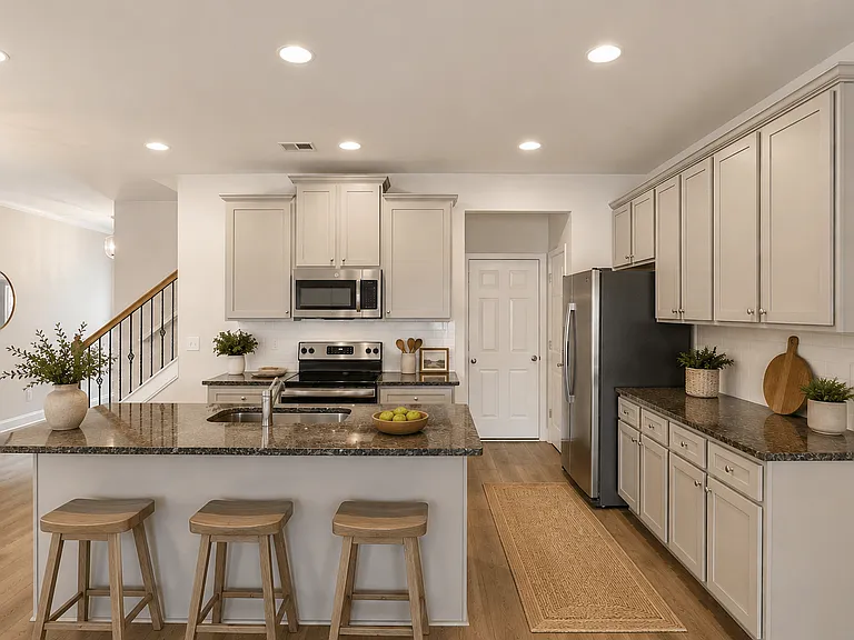 Spacious kitchen with an island, ample storage, stainless steel appliances and view into the living room.