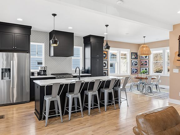Spacious, fully-equipped kitchen for all your cooking needs. Modern appliances, natural lighting, and a large kitchen island with seating for 5. Dining area with additional seating for 4.