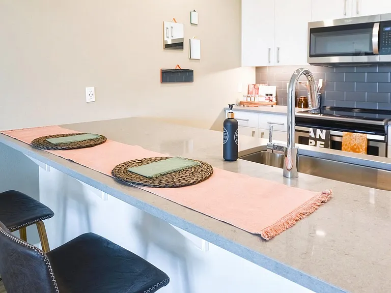 Gourmet kitchens with quartz countertops, sleek cabinetry and tiled backsplash