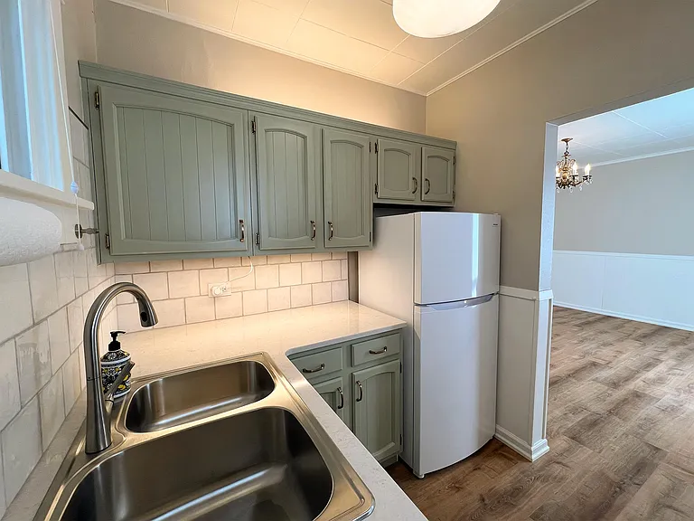 Kitchen with new stove, new fridge, new quarts countertop and stainless steel sink with freshly renovated cabinets with under- and over-cabinet lighting
