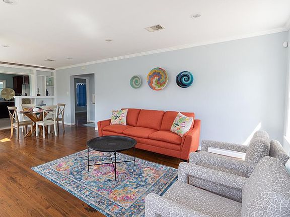 Beautiful and sunny open plan living/dining/kitchen area. New paint, crown molding, and loads of windows.