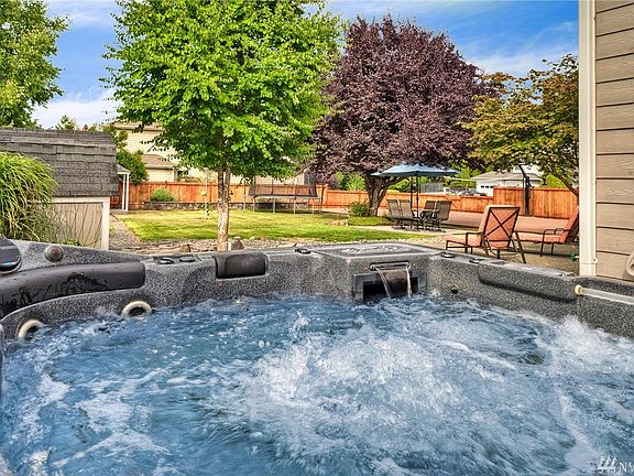 Hot tub is tucked to the side for privacy with views of the gorgeous, established landscape. 
