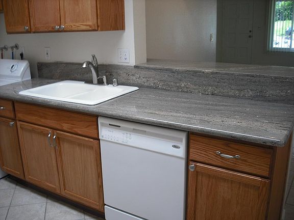 Working kitchen area and washer with view into dinning room.