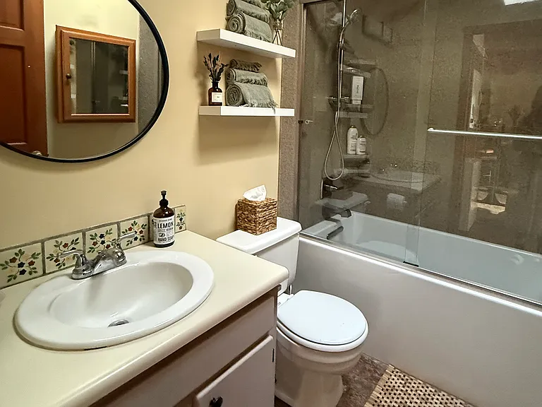 Clean, skylit and well-maintained bathroom with full shower and tub.
