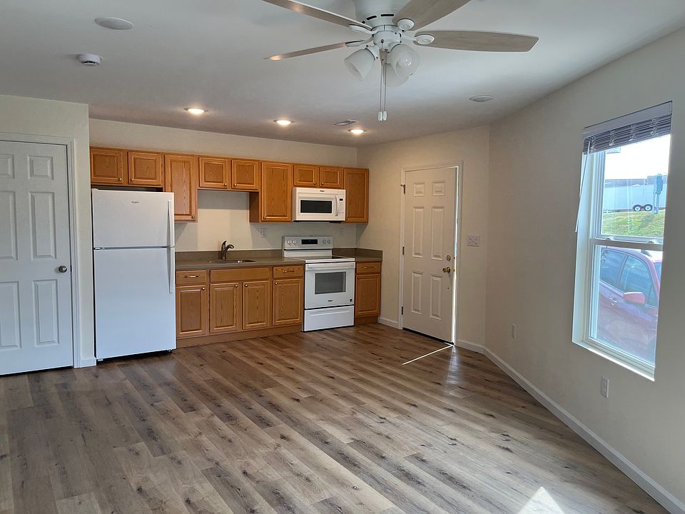 Front entrance door opens into an open kitchen/dining/Living-room area. The door next to the fridge opens to large pantry with adjustable shelves.